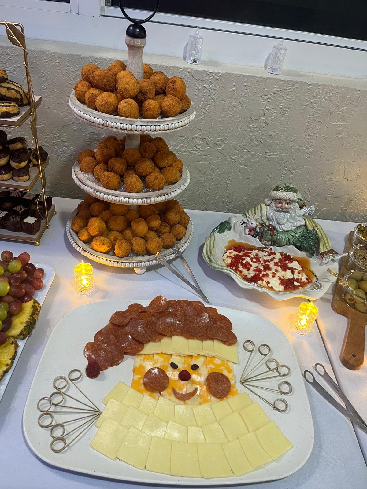 Three-tier croquette stand next to a charcuterie platter arranged like Santa's face