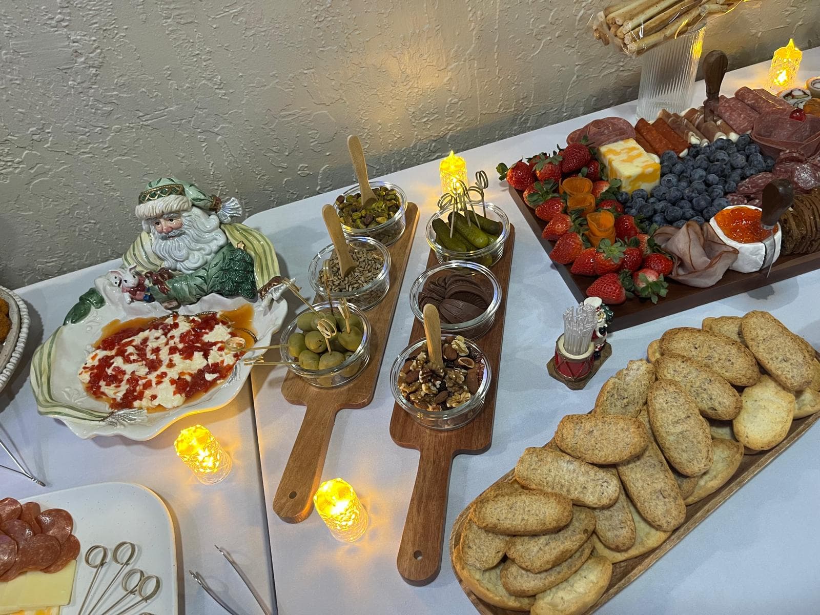 Charcuterie spread with marinated olives, nuts, pickles, chocolate and crostini