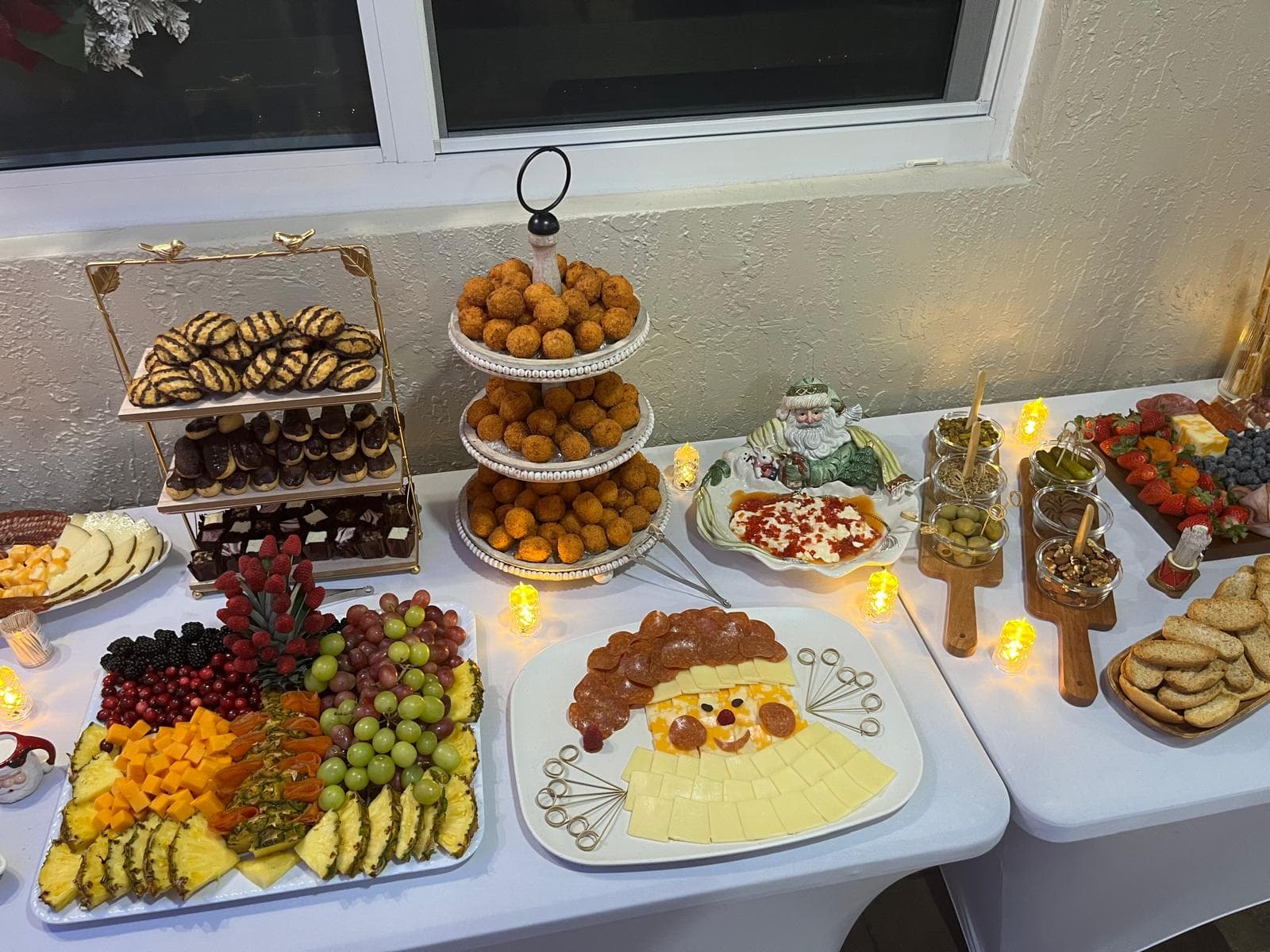 Catering table with a dessert tower, croquette stand and a Santa-face charcuterie platter