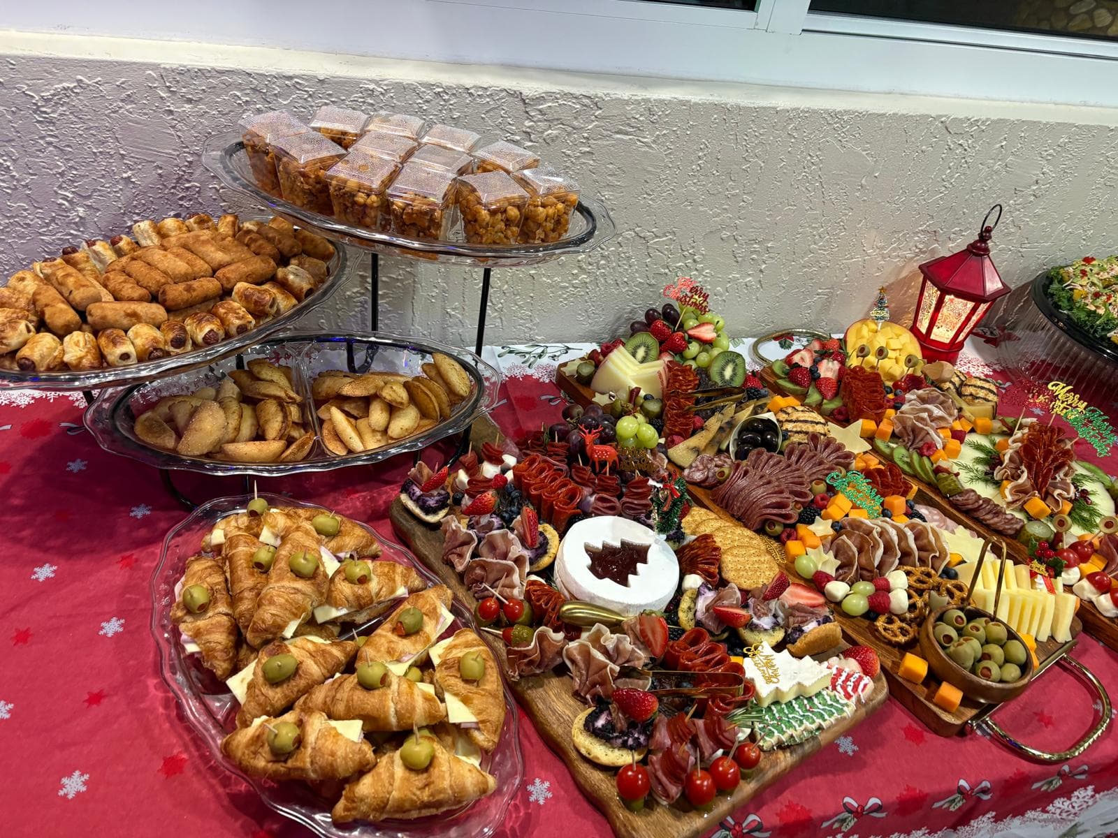 Christmas catering spread with croissant sandwiches, pastry puffs and a holiday charcuterie board