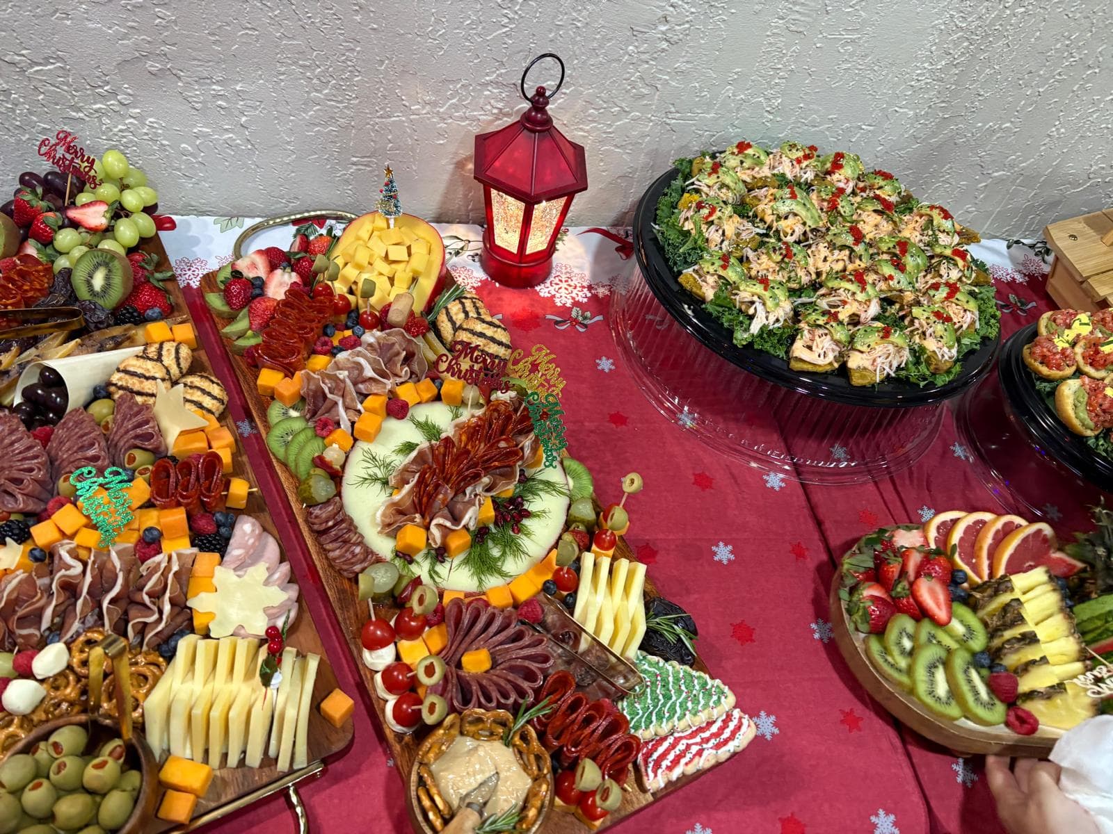 Christmas charcuterie boards next to an avocado and shrimp salad platter
