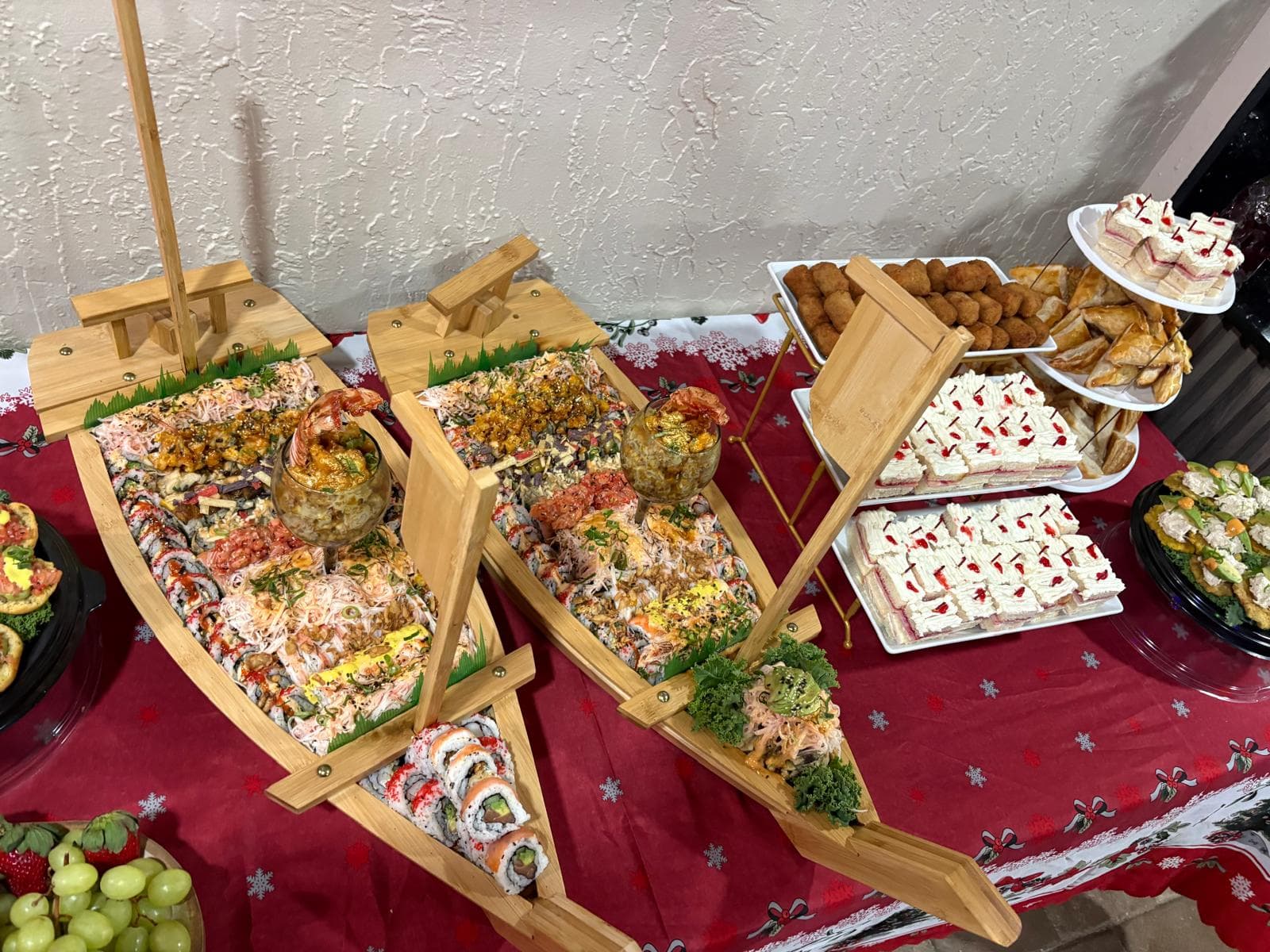 Sushi boat platters served alongside tea sandwiches and pastry puffs